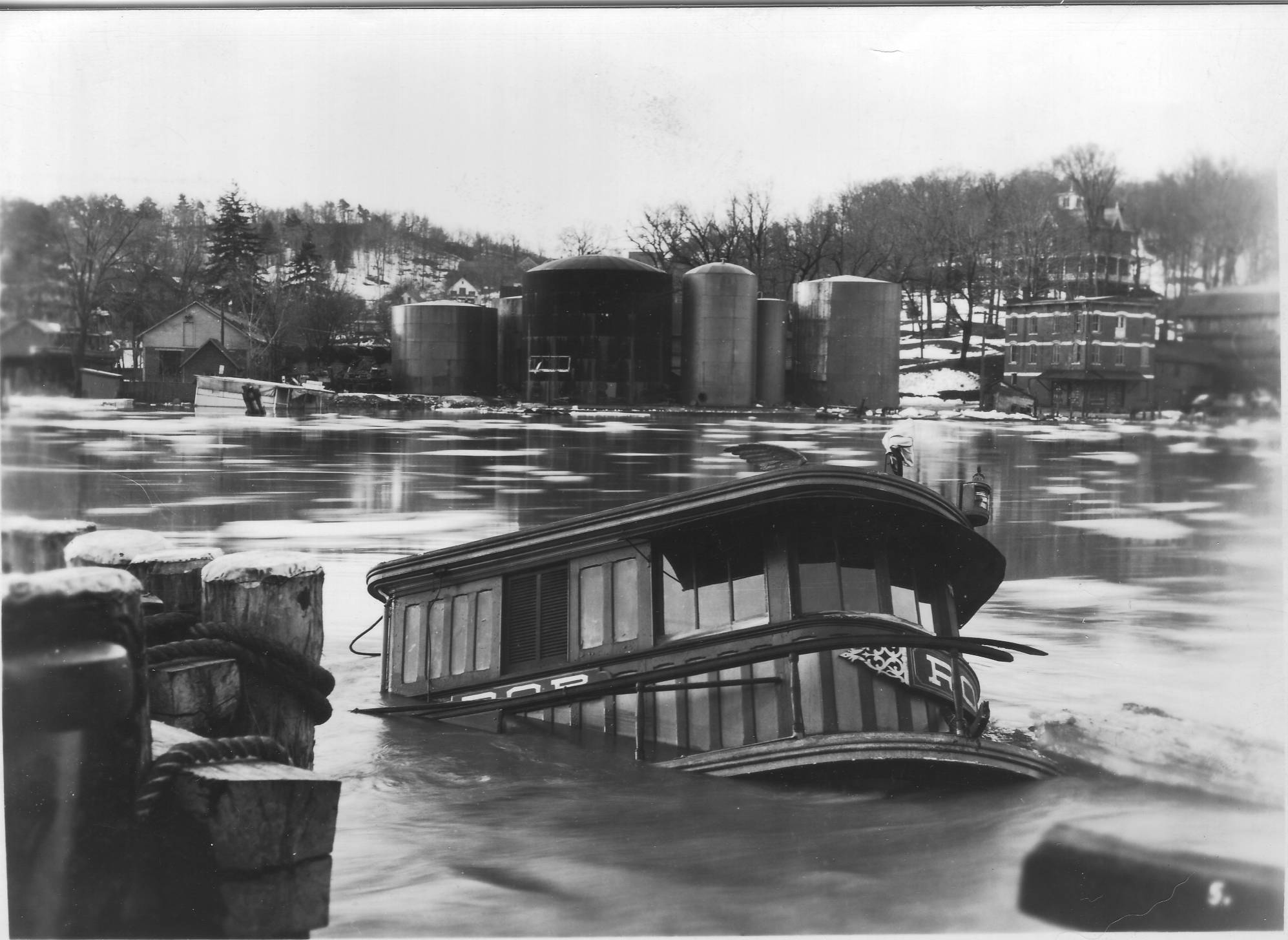 The popular Cornell Tug “Rob” sunk in the Rondout after the freshet (spring thaw flood) of March 1936. This photo shows the swamped boat and Sleightsburg on the other side. The “Rob” was raised and put back into service. Flooding along the Rondout has increased infrequency due to the effects of climate change. The historic neighborhood suffered severe flooding during Tropical Storm Irene and Superstorm Sandy. Water levels along the Hudson River have risen ten inches over the past hundred years, and now many