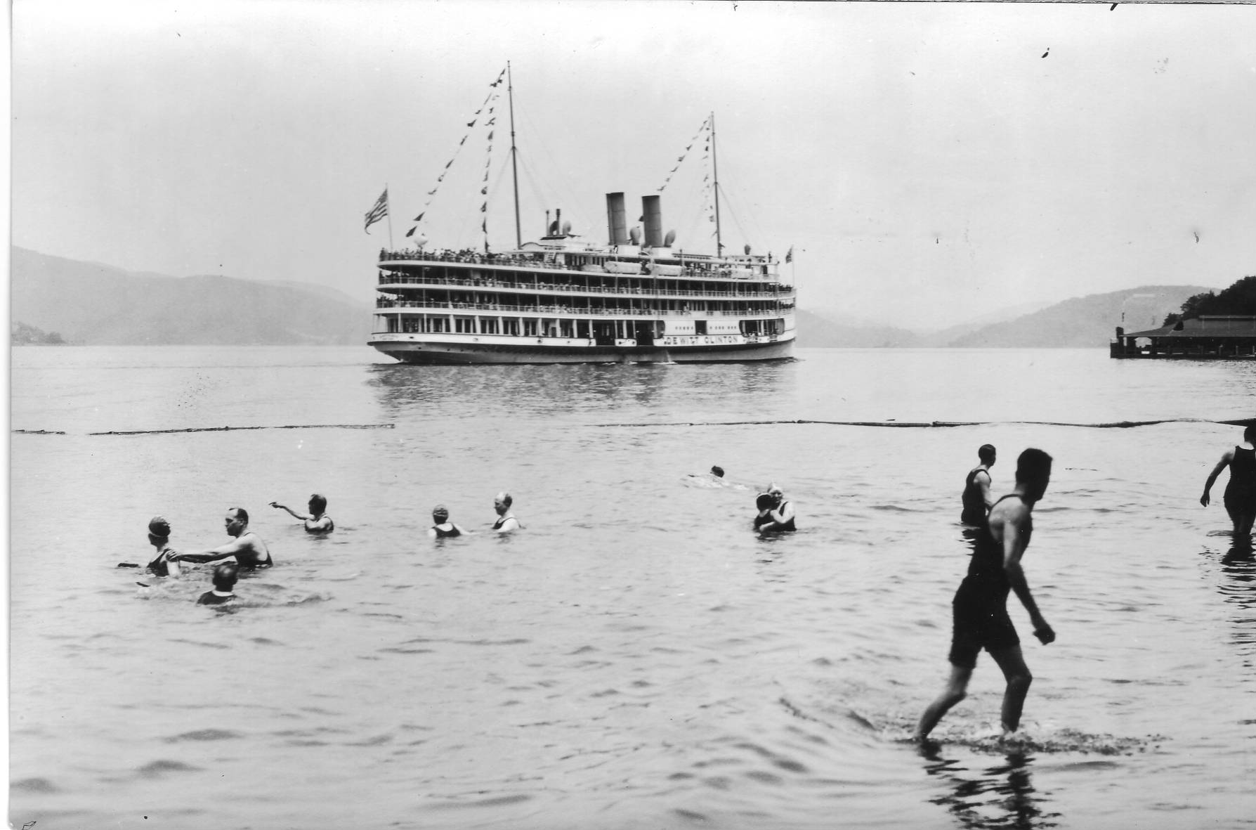 The Hudson River Day Line steamer “DeWitt Clinton” approaching the dock at Indian Point Park at Buchanan, c. 1920s. Park goers swim in the Hudson in the foreground. The Day Line built the park for its passengers. In 1962, the Indian Point Power Plant began operations at this location. The Indian Point Power Plant will close by 2021 after more than 40 years of energy production, in part due to pressure from local environmental groups who received support from New York State Governor Andrew Cuomo. It is unlik