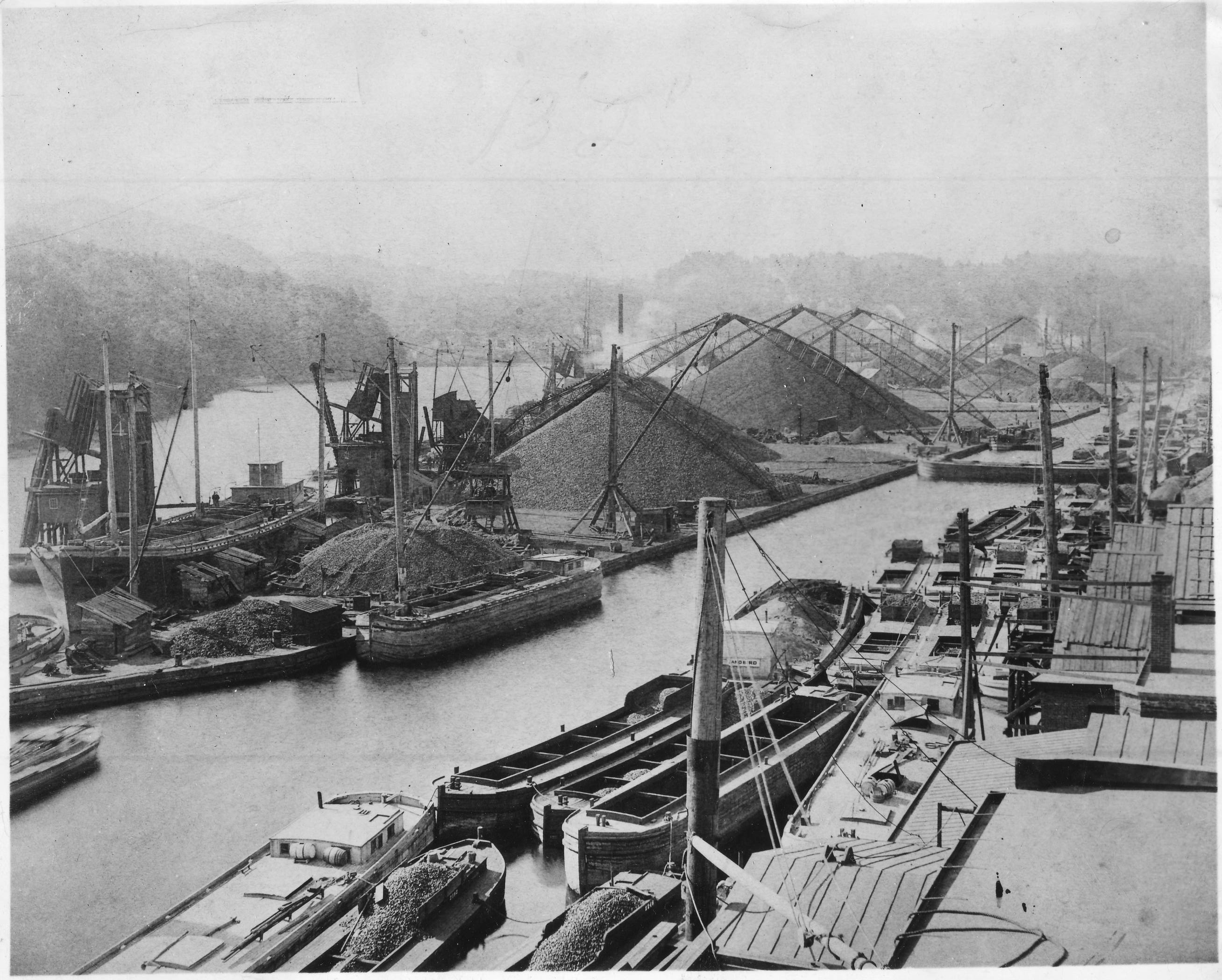 Circa 1880 view of Island Dock shows coal being transported in large quantity on the D&H Canal to Rondout. Note the many canal boats along the creek – some empty and some yet to be unloaded. Rondout became the most important port between Albany and New York for the shipment of coal and building materials like cement and bluestone on the Hudson River. The Rondout remains important; it is the only deep water port between Albany and New York, making it the perfect safe harbor for passenger ships.  HRMM Collect
